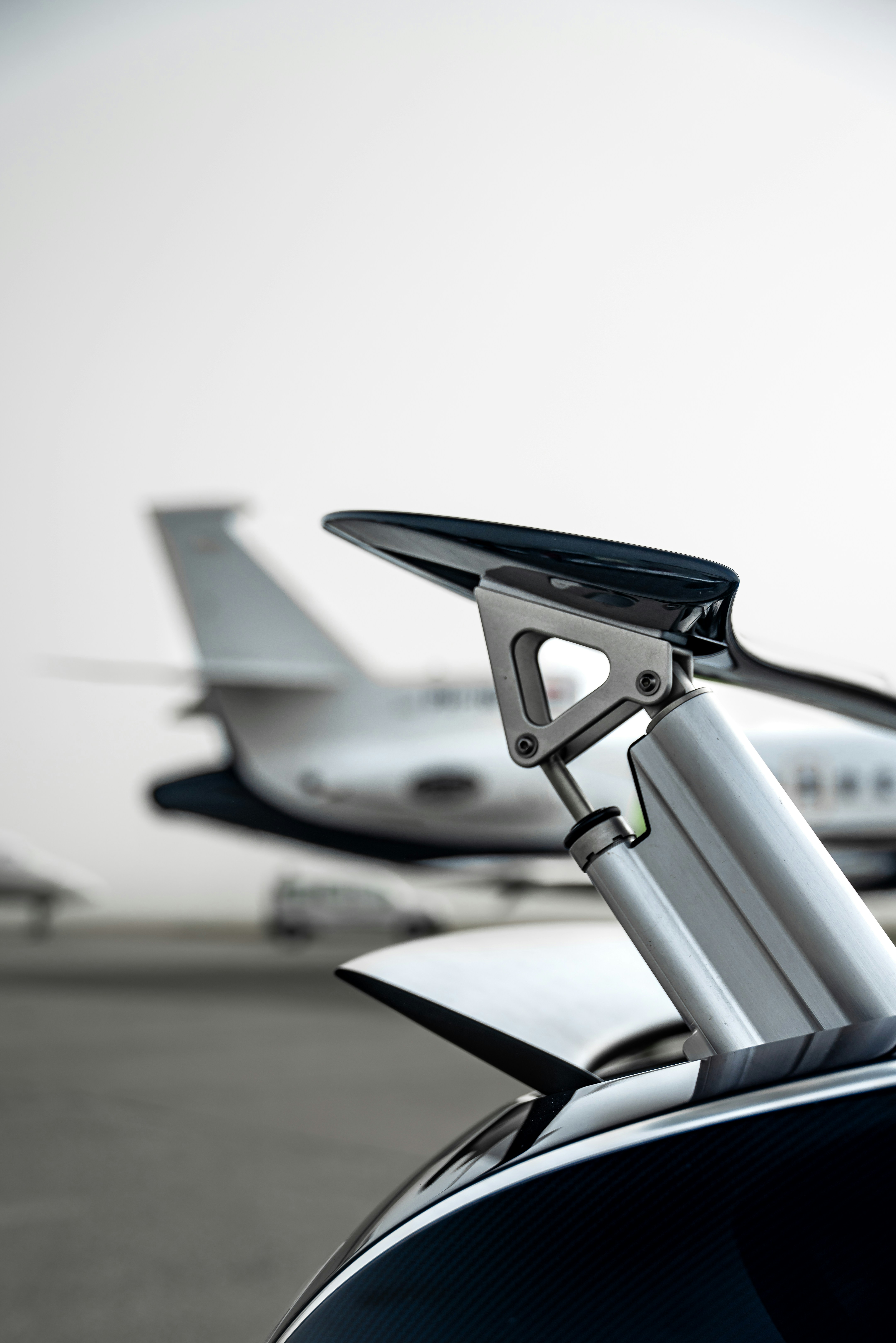 a close up of a car with a plane in the background